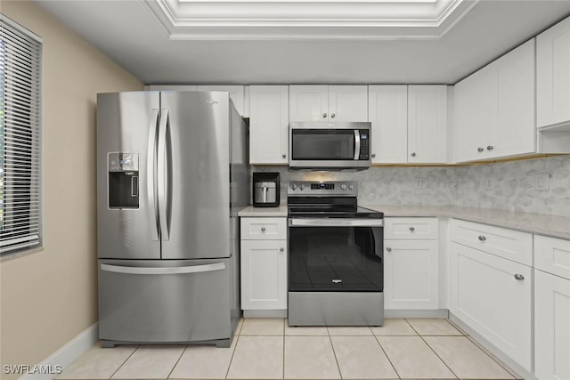 kitchen with tasteful backsplash, light tile patterned floors, white cabinets, and appliances with stainless steel finishes