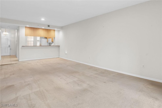 unfurnished living room with light colored carpet and a notable chandelier