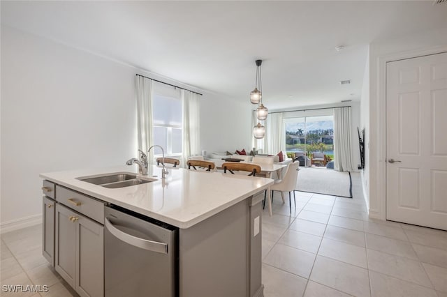 kitchen featuring pendant lighting, sink, a kitchen island with sink, gray cabinetry, and stainless steel dishwasher