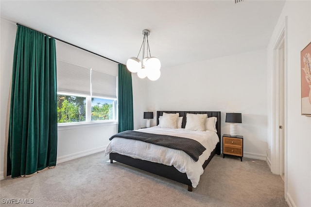 bedroom with light colored carpet and a chandelier