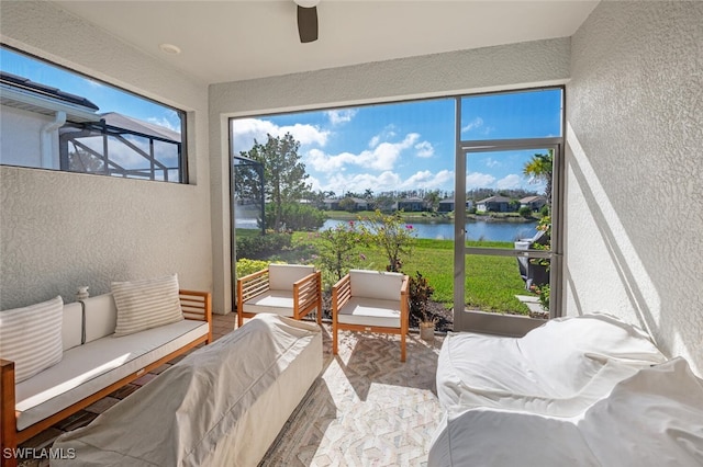 sunroom with a water view and ceiling fan