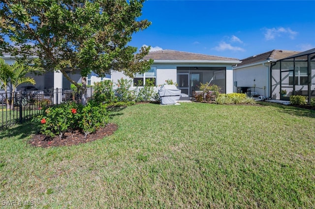 back of house with a yard and a lanai