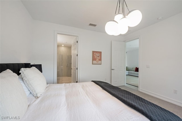 carpeted bedroom featuring an inviting chandelier and ensuite bath