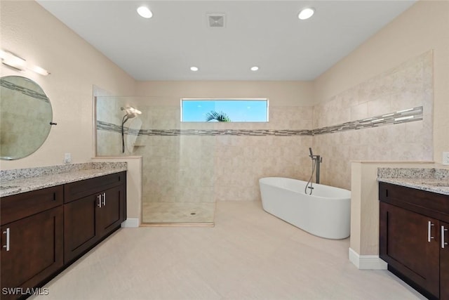 908 SW Embers Ter, Cape Coral, FL 33991 - bathroom featuring a walk in shower, two vanities, a soaking tub, and recessed lighting