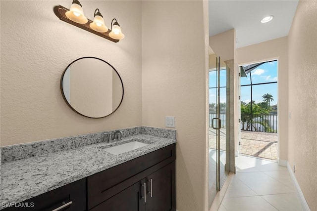 908 SW Embers Ter, Cape Coral, FL 33991 - bathroom featuring vanity, a textured wall, and tile patterned flooring