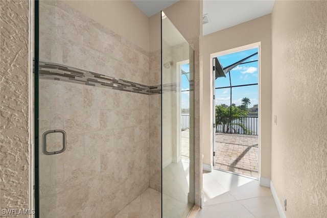 908 SW Embers Ter, Cape Coral, FL 33991 - bathroom featuring a textured wall, a shower stall, and tile patterned floors