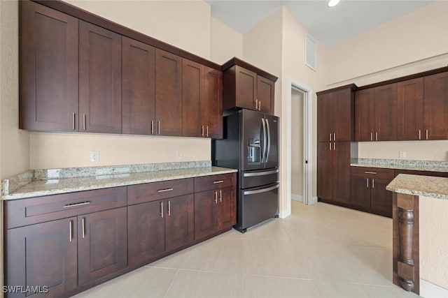 908 SW Embers Ter, Cape Coral, FL 33991 - kitchen with refrigerator with ice dispenser, light tile patterned floors, light stone countertops, and dark brown cabinets