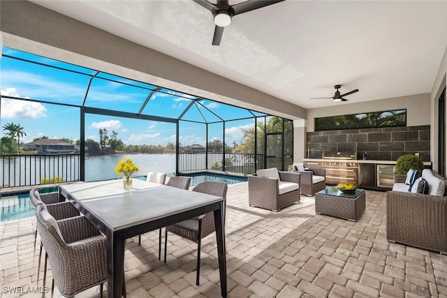 908 SW Embers Ter, Cape Coral, FL 33991 - view of patio featuring a ceiling fan, exterior kitchen, a water view, an outdoor living space, and glass enclosure