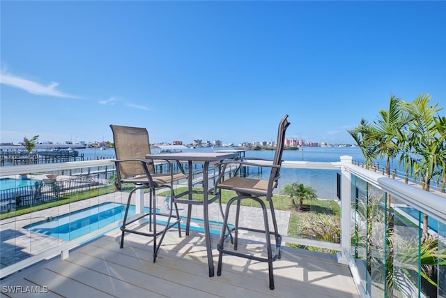 wooden deck featuring a water view and a hot tub