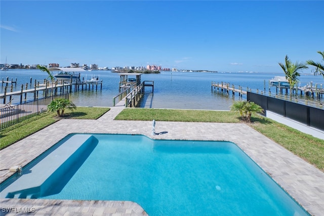 view of swimming pool featuring a yard, a dock, a patio, and a water view