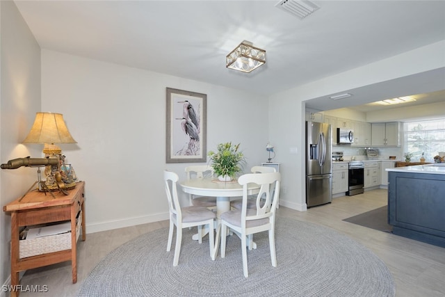 dining space with light hardwood / wood-style floors