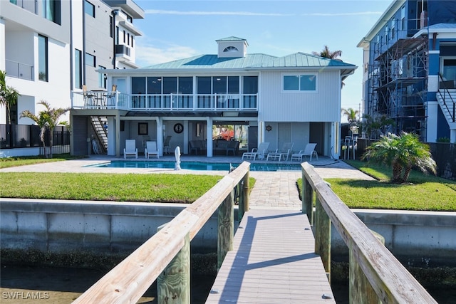 rear view of house featuring a community pool, a yard, and a patio area