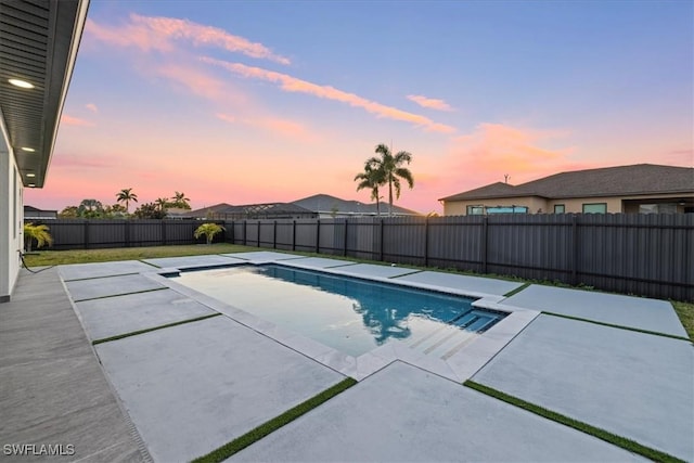 pool at dusk featuring a patio area