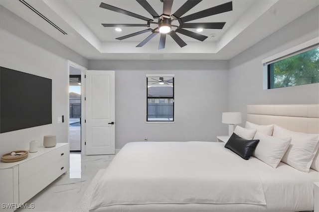 bedroom with a raised ceiling and ceiling fan