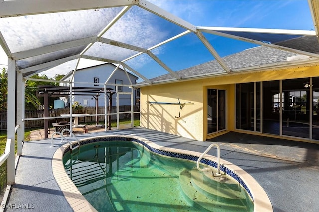 view of swimming pool featuring glass enclosure and a patio area