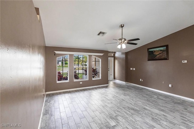 empty room featuring ceiling fan, vaulted ceiling, and light hardwood / wood-style floors