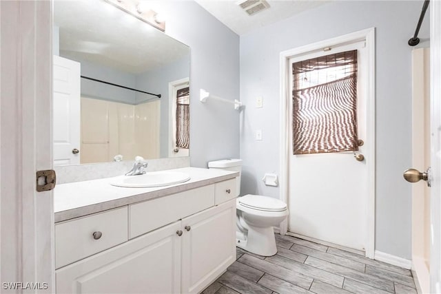 bathroom with vanity, walk in shower, and toilet