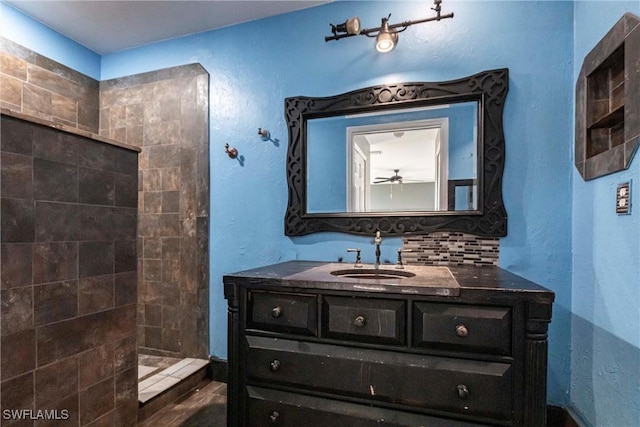 bathroom with vanity, decorative backsplash, and a tile shower