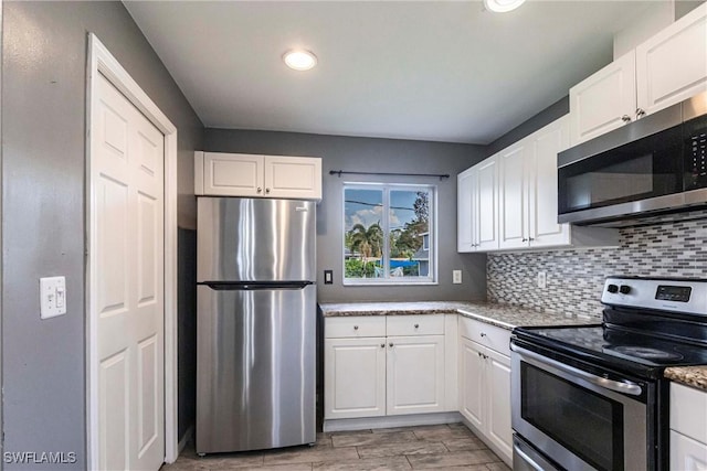 kitchen featuring light stone counters, decorative backsplash, white cabinets, and appliances with stainless steel finishes