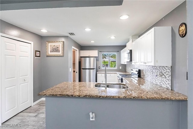 kitchen featuring white cabinetry, stainless steel appliances, kitchen peninsula, and decorative backsplash