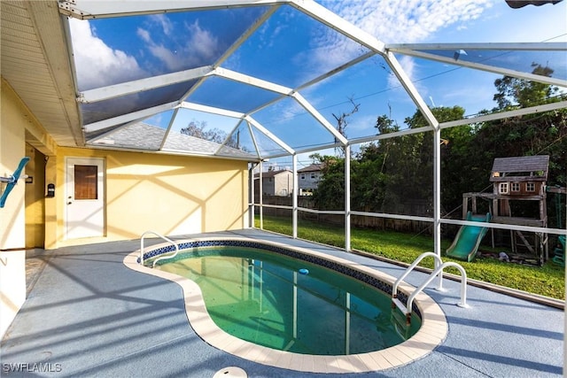 view of swimming pool featuring a playground, a patio, a lanai, and a yard