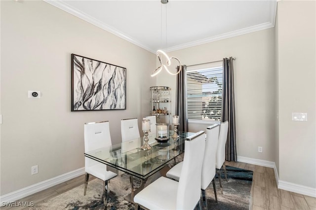 dining area with ornamental molding and light wood-type flooring