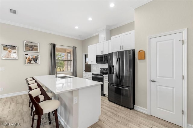 kitchen with range with electric cooktop, sink, a breakfast bar area, a kitchen island with sink, and stainless steel fridge with ice dispenser