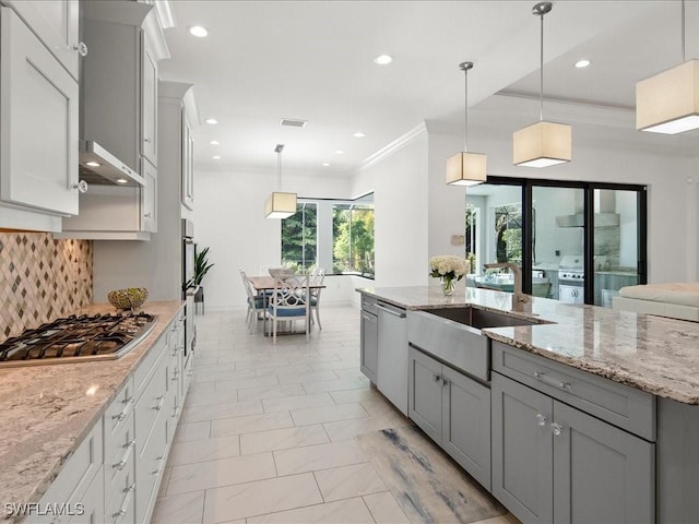 kitchen featuring hanging light fixtures, stainless steel appliances, and light stone countertops