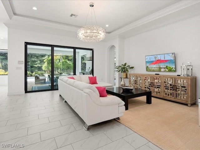 living room featuring crown molding, a notable chandelier, and a tray ceiling