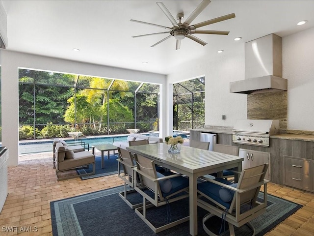 view of patio / terrace with a grill, glass enclosure, ceiling fan, and exterior kitchen