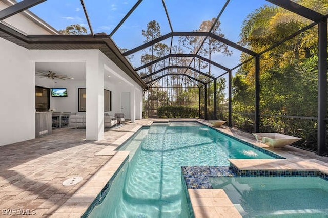 view of pool featuring a lanai, ceiling fan, and a patio area