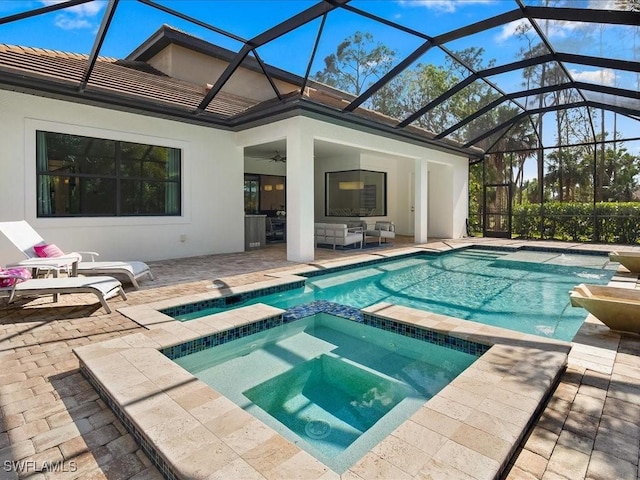 view of pool with a patio, an in ground hot tub, ceiling fan, glass enclosure, and an outdoor living space