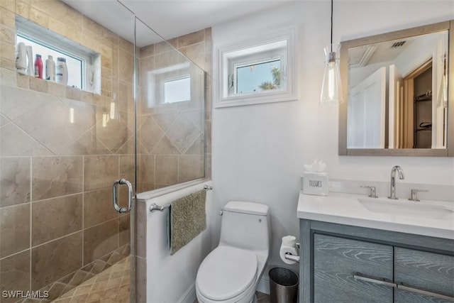 bathroom with walk in shower, a healthy amount of sunlight, vanity, and toilet