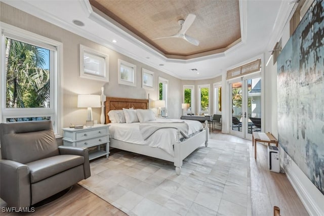 bedroom with a raised ceiling, ornamental molding, and access to exterior