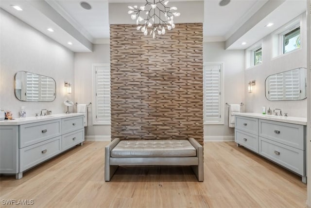 living area with crown molding, a chandelier, and light hardwood / wood-style flooring