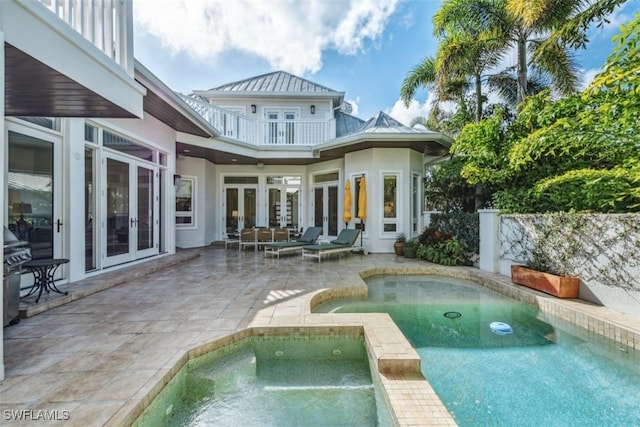 view of pool featuring a patio, french doors, and an in ground hot tub