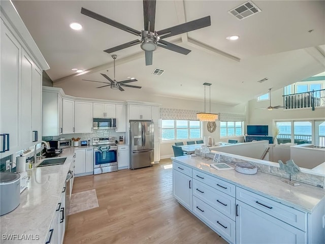 4611 Seair Ln, Upper Captiva, FL 33924 - kitchen featuring light stone countertops, white cabinetry, appliances with stainless steel finishes, and decorative light fixtures