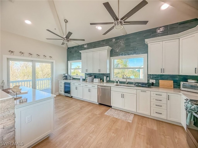 4611 Seair Ln, Upper Captiva, FL 33924 - kitchen with appliances with stainless steel finishes, white cabinetry, sink, wine cooler, and light hardwood / wood-style flooring