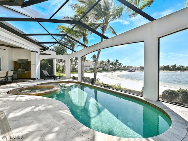 view of pool with a patio area, an in ground hot tub, glass enclosure, and a water view