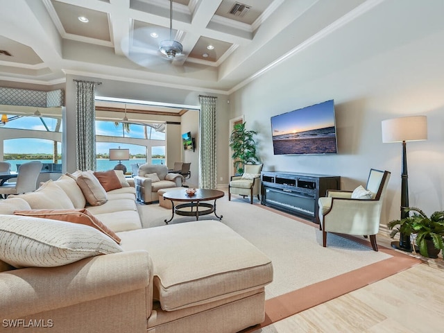 living room featuring crown molding, a towering ceiling, coffered ceiling, and ceiling fan