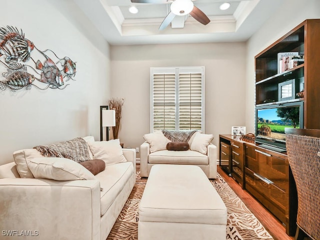 living room featuring ornamental molding, light hardwood / wood-style floors, and ceiling fan