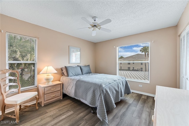 bedroom featuring ceiling fan, a textured ceiling, baseboards, and wood finished floors