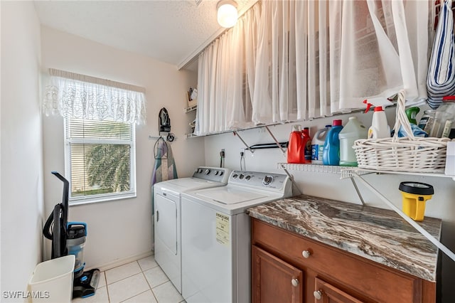 laundry area with light tile patterned floors, cabinet space, and washer and dryer