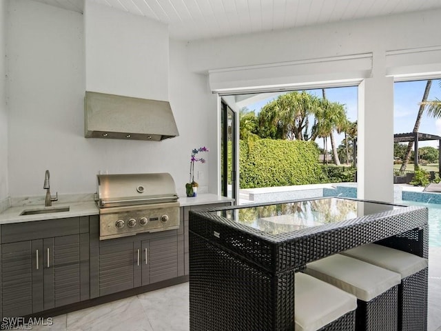 kitchen featuring sink and wall chimney range hood