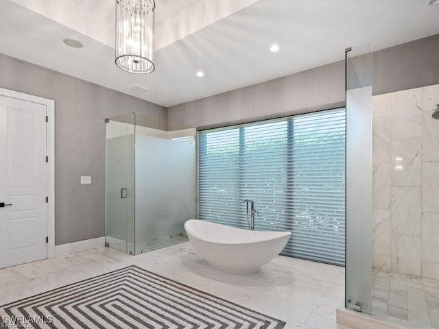 bathroom with an inviting chandelier and separate shower and tub