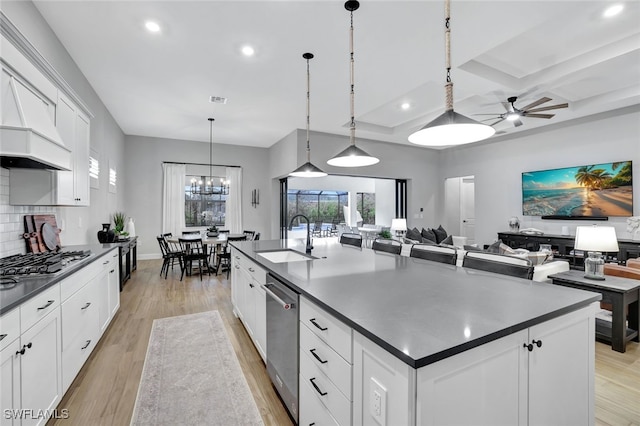 kitchen featuring pendant lighting, white cabinetry, a large island, and sink