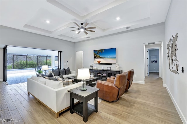 living room with a high ceiling, coffered ceiling, ceiling fan, beam ceiling, and light hardwood / wood-style flooring