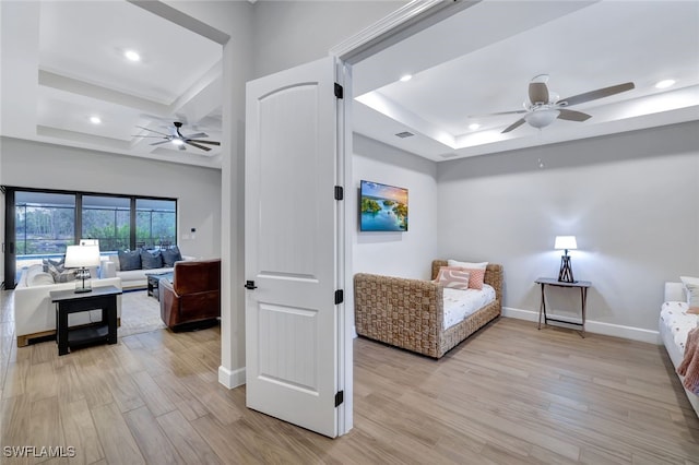 bedroom featuring a tray ceiling, coffered ceiling, ceiling fan, and light hardwood / wood-style flooring