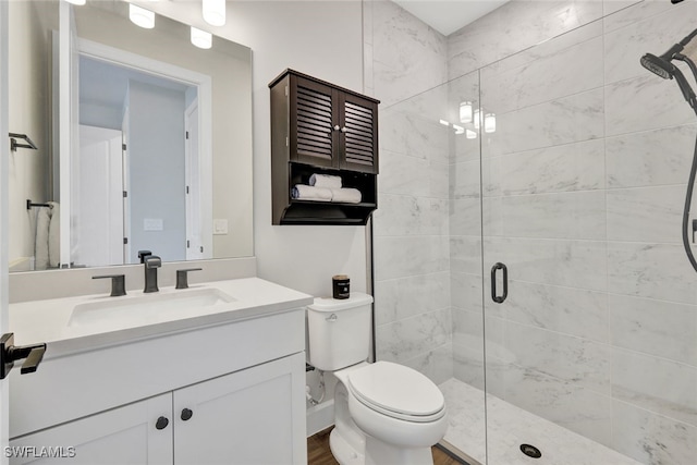 bathroom with vanity, toilet, a shower with shower door, and wood-type flooring