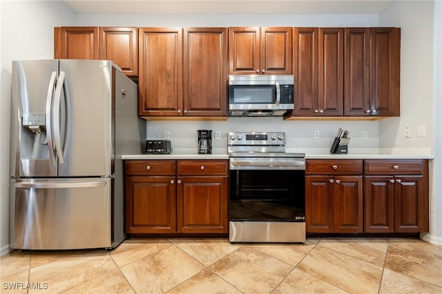 kitchen featuring stainless steel appliances and light tile patterned floors